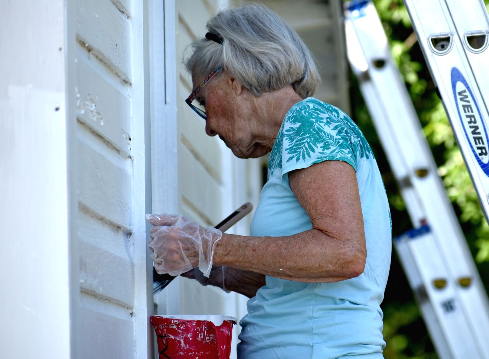 Volunteers paint historic Cigar Cottage at History Park